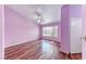 This bedroom features laminate flooring, soft lilac paint and a ceiling fan at 3413 Freestone Ln, North Las Vegas, NV 89032