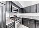 Close-up of stainless steel stove and microwave with dark cabinets and granite counters at 3413 Freestone Ln, North Las Vegas, NV 89032