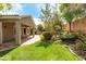 Landscaped backyard featuring lush green lawn, covered patio, and vibrant rose bushes at 3483 French Daisy St, Las Vegas, NV 89135