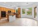 Well-lit kitchen features wooden cabinets, modern appliances, an island, and picturesque backyard views at 3483 French Daisy St, Las Vegas, NV 89135