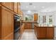 Functional kitchen with wood cabinets, stone countertops, stainless steel appliances, and backyard views at 3483 French Daisy St, Las Vegas, NV 89135