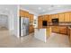 Spacious kitchen with wooden cabinets, stainless steel refrigerator, an island, and modern appliances at 3483 French Daisy St, Las Vegas, NV 89135