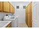 This laundry room features updated machines, ample cabinet storage space, and neutral paint at 3483 French Daisy St, Las Vegas, NV 89135