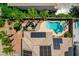 Aerial view of a home with solar panels, a pool, a hot tub, and an outdoor seating area surrounded by landscaping at 3614 Coventry Gardens Dr, Las Vegas, NV 89135