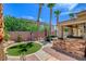 Private backyard retreat with built in kitchen, grassy area, patio, and tasteful desert landscaping at 3614 Coventry Gardens Dr, Las Vegas, NV 89135