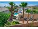 Backyard featuring a pool, an outdoor kitchen, a seating area, and landscaped greenery around the property perimeter at 3614 Coventry Gardens Dr, Las Vegas, NV 89135