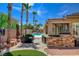 This landscaped backyard boasts a stone-clad outdoor kitchen, seating, a covered patio, and an outdoor living area at 3614 Coventry Gardens Dr, Las Vegas, NV 89135