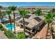 Home's backyard oasis with a swimming pool, outdoor kitchen, and lounge area amid palm trees and manicured landscaping at 3614 Coventry Gardens Dr, Las Vegas, NV 89135