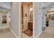 Powder room featuring an antique vanity, decorative mirror, and tile walls, with hallway and bedroom access at 3614 Coventry Gardens Dr, Las Vegas, NV 89135