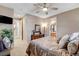 Bright bedroom featuring comfortable furnishings, an en-suite bathroom, and a ceiling fan at 3614 Coventry Gardens Dr, Las Vegas, NV 89135