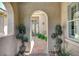 Inviting entryway with stone pathway, arched openings, and decorative potted plants at 3614 Coventry Gardens Dr, Las Vegas, NV 89135