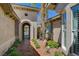 Charming front entrance with arched gate and pathway, surrounded by desert landscaping at 3614 Coventry Gardens Dr, Las Vegas, NV 89135