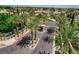 Gated entrance with stone pillars, mature palm trees, and lush landscaping at 3614 Coventry Gardens Dr, Las Vegas, NV 89135