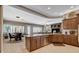 Open-concept kitchen with an island and view into the living area with a fireplace at 3614 Coventry Gardens Dr, Las Vegas, NV 89135