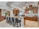 Spacious kitchen with granite counters, dark wood cabinets, stainless steel appliances and seating at the island at 3614 Coventry Gardens Dr, Las Vegas, NV 89135