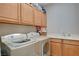 Laundry area with modern appliances, ample storage, and a convenient utility sink at 3614 Coventry Gardens Dr, Las Vegas, NV 89135