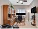 Bright office with custom wood cabinets, dual monitors, and ceiling fan at 3614 Coventry Gardens Dr, Las Vegas, NV 89135