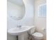 Clean half-bath with modern pedestal sink, toilet, and a large round mirror at 378 Gracious Way, Henderson, NV 89011