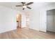 Bedroom with neutral walls, ceiling fan and hardwood floors opening to bathroom and closet at 378 Gracious Way, Henderson, NV 89011