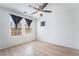 Bright bedroom with two windows, a ceiling fan, neutral walls and hardwood floors at 378 Gracious Way, Henderson, NV 89011