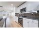 Close-up of a kitchen with stainless steel oven, microwave, and backsplash, and modern white cabinets at 378 Gracious Way, Henderson, NV 89011