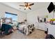 Bright bedroom with a ceiling fan, carpeted floors, and natural light from large windows at 3880 Rudek St, Pahrump, NV 89061
