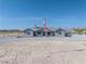 Single story home with a covered front porch, desert landscaping, and an American flag at 3880 Rudek St, Pahrump, NV 89061