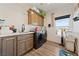 Well-equipped laundry room with wood cabinets, sink, washer, dryer, and natural light at 3880 Rudek St, Pahrump, NV 89061