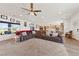 Open concept living space with large sectional, kitchen view, and natural light from backyard-facing windows at 3880 Rudek St, Pahrump, NV 89061