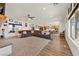 Open concept living space with large sectional, kitchen view, and natural light from backyard-facing windows at 3880 Rudek St, Pahrump, NV 89061