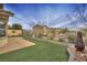Landscaped backyard with artificial turf, desert flora, and a decorative fountain at 4017 Gliding Gulls Ave, North Las Vegas, NV 89084