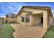 Backyard featuring artificial turf, a covered patio, and tan stucco exterior at 4017 Gliding Gulls Ave, North Las Vegas, NV 89084
