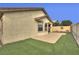 Rear exterior view featuring artificial turf, stucco walls, and a covered patio at 4017 Gliding Gulls Ave, North Las Vegas, NV 89084