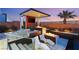 Outdoor patio area with a fire pit, lounge chairs, and a view of the backyard at 4024 Desert Trace Ct, Las Vegas, NV 89129