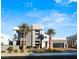 Modern home exterior with sleek lines, palm trees, and a well-maintained front yard under a bright blue sky at 4024 Desert Trace Ct, Las Vegas, NV 89129