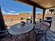 Charming backyard patio with a round metal table, chairs, and a well-manicured, low-maintenance landscape at 4132 Ancient Well Ct, Las Vegas, NV 89135