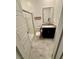Updated bathroom with a glass-enclosed shower, dark vanity, and light tile flooring at 4132 Ancient Well Ct, Las Vegas, NV 89135