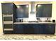 Stylish kitchen featuring dark cabinetry, stainless steel appliances and granite countertops at 4132 Ancient Well Ct, Las Vegas, NV 89135