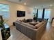Cozy living room with a plush sofa, media center, and natural light from large windows at 4132 Ancient Well Ct, Las Vegas, NV 89135