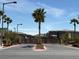 Wide street leading to the community entrance with neatly landscaped median and residential buildings at 4132 Ancient Well Ct, Las Vegas, NV 89135
