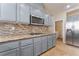 Modern kitchen with gray cabinets, granite countertops, stainless steel appliances, and decorative backsplash at 4133 Perfect Lure St, Las Vegas, NV 89129