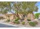 Charming single-story home with a well-manicured desert landscape, mature trees, and a two-car garage at 4187 Pacifico Ln, Las Vegas, NV 89135