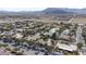 Expansive aerial view of the neighborhood and home surrounded by desert landscape and mountains at 4594 Blue Mesa Way, Las Vegas, NV 89129