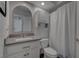 Cozy bathroom with a white vanity, a toilet, and a shower with a curtain; an elegant mirror on the wall at 4594 Blue Mesa Way, Las Vegas, NV 89129