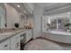 Luxurious bathroom with double vanity, soaking tub, elegant finishes, and abundant natural light at 4594 Blue Mesa Way, Las Vegas, NV 89129