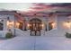 Elegant front entrance features a decorative metal gate and ornate double doors, set against a vibrant sunset backdrop at 4594 Blue Mesa Way, Las Vegas, NV 89129
