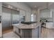 A bright kitchen with a central island, granite countertops, and stainless steel appliances at 4594 Blue Mesa Way, Las Vegas, NV 89129