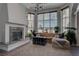 Beautiful living room with large windows, fireplace, stylish furniture, and modern lighting at 4594 Blue Mesa Way, Las Vegas, NV 89129