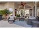 Inviting outdoor living space with comfortable seating, palm trees, and a ceiling fan at 4594 Blue Mesa Way, Las Vegas, NV 89129