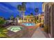 Backyard pool with a spa, string lights, patio and an exterior view of the home at night at 4594 Blue Mesa Way, Las Vegas, NV 89129